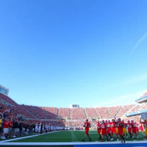 Clemson Tigers and Georgia Tech Yellow Jackets warming up on the field under clear skies.