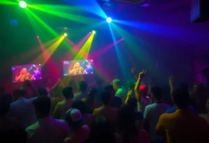 Vibrant atmosphere in a nightclub with colorful lighting and people enjoying their time.