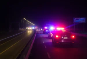 Traffic accident scene on I-75 at night with police presence.