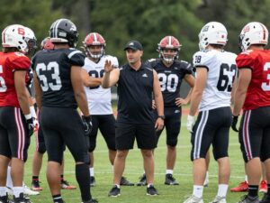 Coach discussing strategy with players on the field