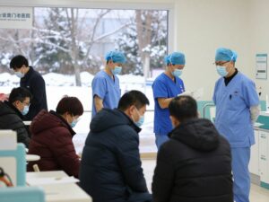 Healthcare workers in masks attending to patients in a hospital during winter in Georgia.