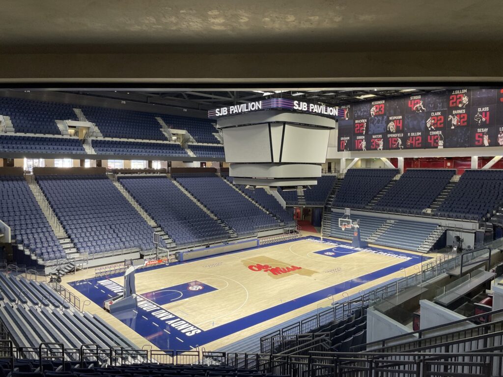 Indoor basketball arena with empty seats and court lights
