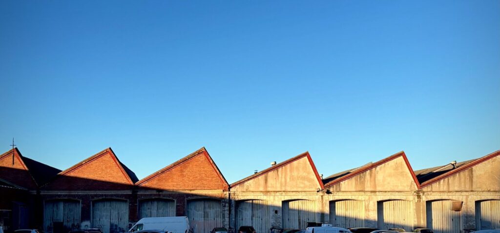 Row of gabled industrial buildings under a clear sky