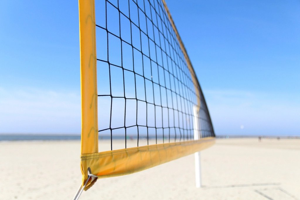 Volleyball players at the net in an indoor arena