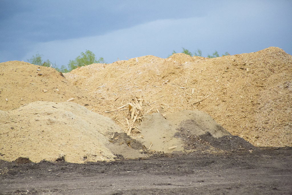 Large piles of wood chips at a processing yard